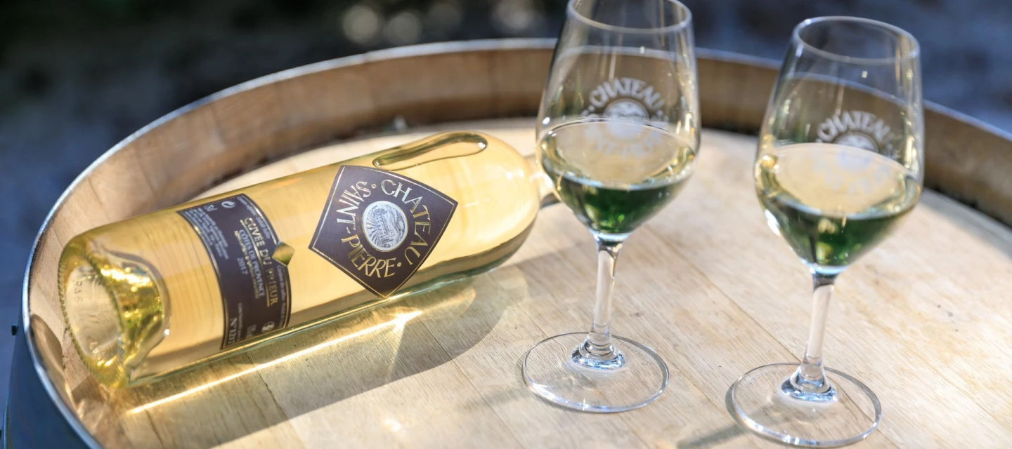 Wine bottle and glasses placed on a wooden barrel